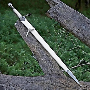 May include: A long sword with a white scabbard and a silver-toned hilt. The hilt features a cross-guard with intricate metal detailing and a white grip. A small white strap is attached to the scabbard, which ends in a pointed silver-toned metal tip.