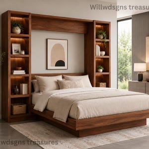 May include: A wooden wall bed unit featuring integrated vertical shelving towers on both sides with internal lighting. The bed frame is low-profile with light beige bedding. A framed abstract print hangs on the wall between the two shelving units.