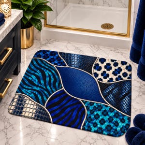 May include: A rectangular bath mat featuring a patchwork design of various blue and black patterns, including zebra stripes, floral motifs, and textured leather-like sections, all separated by thin silver lines in a modern, segmented layout.