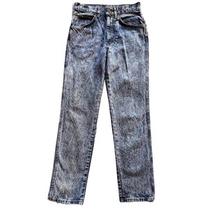 May include: High-waisted denim jeans featuring a distinct acid-wash finish in shades of blue and white. These pants include a button fly closure, two front pockets, and a straight-leg cut with visible stitching along the seams and hemline.