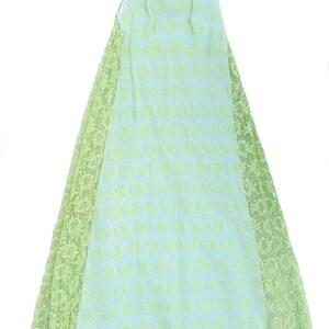 May include: A sleeveless floor-length dress featuring a light blue base layer with a repeating oval pattern and a sheer light green lace overlay on the sides and neckline. The garment has a round neck and a straight, flowing silhouette.
