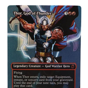 May include: A rectangular trading card titled Thor, God of Thunder, featuring a comic-style illustration of a warrior with a winged helmet, blue and red cape, and armor. The card text details abilities, power, and toughness stats of 5/5.