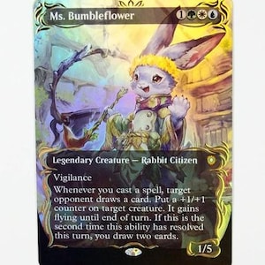 Peut inclure: Une carte à collectionner holographique représentant Ms. Bumbleflower, un personnage lapin citoyen portant une couronne de fleurs jaunes. La carte affiche le texte Ms. Bumbleflower, Legendary Creature, Rabbit Citizen, Vigilance et les règles du jeu, avec une valeur de 1/5 dans le coin inférieur.