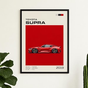 Peut inclure: Une affiche encadrée représentant une voiture de sport Toyota Supra rouge de profil sur un fond rouge uni. Le texte indique Toyota Supra, 2019, 382 HP, 498 NM, 4.1 SEC, 1540 KG, 250 KM/H et 3.0 L sur une bordure de couleur crème.