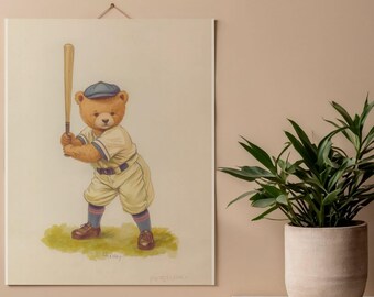 May include: A rectangular wall hanging featuring a watercolor illustration of a brown teddy bear dressed in a vintage baseball uniform, including a blue cap and cream-colored jersey, holding a wooden bat while standing on a patch of green grass.