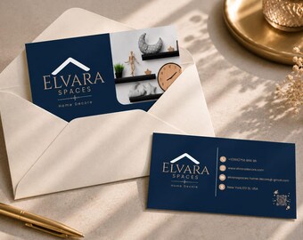 May include: Two rectangular business cards in dark navy blue with gold lettering and a white envelope. One card features the Elvara Spaces Home Decore logo and a photo of home decor items. The other card displays contact details and a QR code.