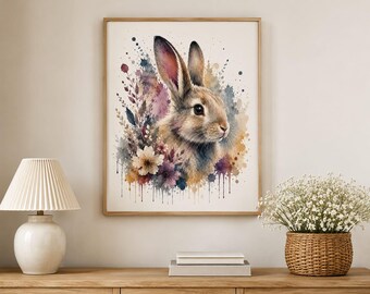 May include: A framed wall art print featuring a watercolor illustration of a brown rabbit surrounded by colorful floral elements and botanical sprigs. The artwork displays a splattered paint effect with shades of purple, blue, and orange.
