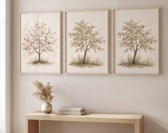 May include: Three framed wall art prints featuring watercolor-style illustrations of trees. The left print shows a tree with pink blossoms, while the center and right prints depict trees with green foliage and small purple flowers at the base.