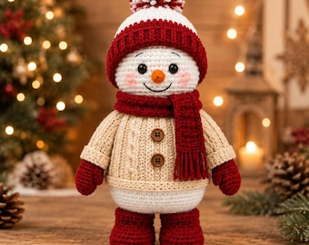 May include: A crocheted snowman doll wearing a white and red pom-pom hat, a red scarf, a beige cable-knit sweater with two brown buttons, red mittens, and red boots. The snowman has a small orange carrot nose, black eyes, and pink cheeks.