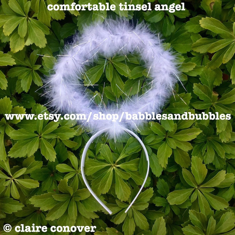 May include: White feather angel halo headband with silver tinsel. The headband is white and has a comfortable fit. www.etsy.com/shop/babblesandbubbles &copy; claire conover