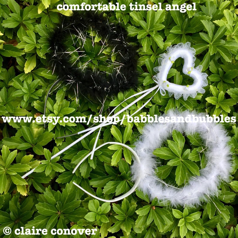 May include: Three angel headbands, one black with silver tinsel, one white with silver tinsel, and one white with a heart-shaped halo. The headbands are on a bed of green leaves. The text "www.etsy.com/shop/babblesandbubbles" is visible in the image.