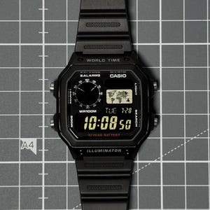 May include: A black Casio digital watch with a resin strap, featuring a world map display, 5 alarms, and a 10-year battery indicator. The screen shows the time 10:08:50, the date TUE 7-28, and the text WORLD TIME, WR100M, and ILLUMINATOR.