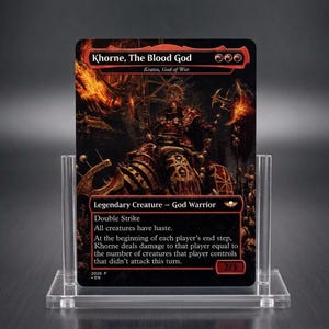 May include: A rectangular trading card titled Khorne, The Blood God, featuring a dark, fiery illustration of a warrior in red armour. The card text includes Legendary Creature, God Warrior, and game mechanics, displayed in a clear acrylic stand.