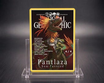 Può includere: Una carta collezionabile rettangolare con l'illustrazione di un dinosauro con piume arancioni, armatura metallica e il testo National Geographic, Pantlaza Sun-Favored e le regole del gioco. La carta è su un supporto in acrilico trasparente.