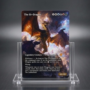 May include: A Magic: The Gathering trading card titled The Ur-Dragon, featuring a large dragon illustration against a stormy sky, displayed in a clear acrylic stand. The card text includes Eminence, Flying, and power/toughness stats of 10/10.