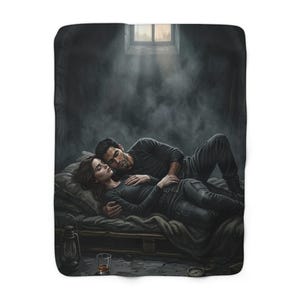 May include: A rectangular throw blanket featuring a dark, atmospheric illustration of two people lying together on a bed. They are dressed in black clothing, surrounded by shadows and smoke, with a lantern and a glass nearby in a dim room.