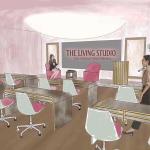 Op de afbeelding: Een studioruimte met rijen metalen bureaus met witte en roze stoelen, een podiumgedeelte met twee roze fauteuils, een houten katheder en een groot scherm met de tekst THE LIVING STUDIO. Een grote kamerplant staat bij het podium.