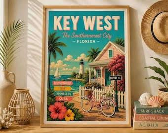 Puede incluir: Un póster de viaje enmarcado de Key West, Florida, con una casa rosa, un faro, un velero y una bicicleta. El texto dice KEY WEST, The Southernmost City, FLORIDA, SOUTHERNMOST POINT, 90 MILES TO CUBA y DUVAL ST. Flores tropicales vibrantes aparecen en primer plano.