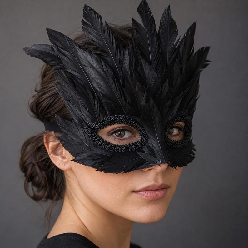 May include: A black masquerade mask adorned with layered black feathers extending upwards and outwards. The eye openings are framed with a decorative black braided trim, and the mask is secured with a simple black elastic strap around the head.