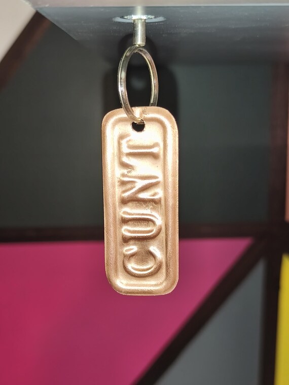 Solid copper, 3D mold-pressed rude word keyring — the craftsmanship elevates a cheeky joke into a genuinely tactile, weighty little object.