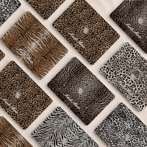 May include: A collection of laptop skins featuring various animal print patterns including leopard, tiger, and zebra designs. Each skin displays a central cutout for an Apple logo and includes the cursive text Nicole Marie printed on the surface.