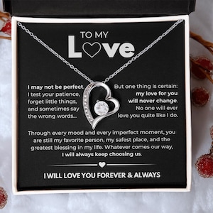 May include: A silver-toned heart-shaped pendant necklace with a central round cubic zirconia stone, presented in a black gift box. The box insert features the text TO MY LOVE and a long message expressing commitment, ending with I WILL LOVE YOU FOREVER & ALWAYS.