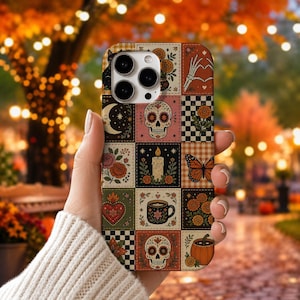 May include: A phone case featuring a grid of square illustrations including sugar skulls, a burning candle, a coffee mug, a butterfly, a pumpkin, flowers, a crescent moon, and a heart, all rendered in a warm, autumnal color palette.