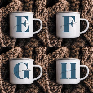 May include: Four white enamel mugs with a silver rim, each featuring a large blue serif letter E, F, G, or H. The text "your name" is printed in a thin, black cursive script across the center of each letter on these four individual mugs.