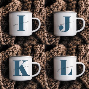 May include: Four white enamel mugs with a silver rim, each featuring a large blue letter I, J, K, or L. Below each letter, the text your name is written in a thin, black, cursive script. The mugs have a side handle and a smooth finish.