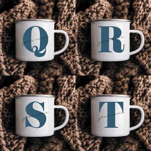 May include: Four white enamel mugs with a silver rim, each featuring a large blue letter Q, R, S, or T. Below each letter, the text your name is written in a thin black cursive script. The mugs have a side handle and a smooth finish.