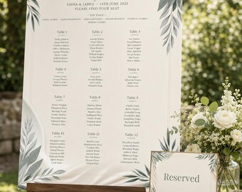 Puede incluir: Un gran plano de asientos de boda sobre un caballete de madera, con el texto Seating Chart, Emma & James, 14th June 2025 y una lista de mesas e invitados. El cartel tiene ilustraciones de hojas verdes en las esquinas y fondo crema.