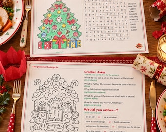 Puede incluir: Dos manteles individuales rectangulares de papel con bordes rojos. El superior presenta una ilustración de un árbol de Navidad a color, una sopa de letras y el texto Christmas Word Search. El inferior muestra el contorno de una casa de jengibre en blanco y negro, chistes y preguntas de tipo Would you rather.
