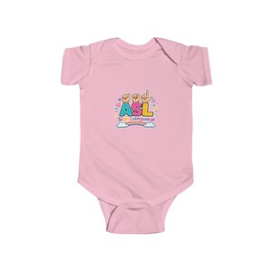 Peut inclure: Un body pour bébé rose clair avec un motif coloré sur la poitrine. Le design affiche les lettres ASL dans une police grasse et multicolore, avec des mains effectuant des gestes en langue des signes au-dessus du texte et les mots Sign Language.