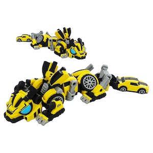 May include: Two yellow and black robotic animal figures with blue eyes and mechanical details. Each figure features a small yellow car attached to its tail, with visible wheels, articulated limbs, and geometric plating throughout the design.