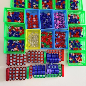 May include: A collection of plastic storage baskets filled with assorted small items, including round bottle caps printed with letters and numbers, metal keychains, and rectangular plastic components with mechanical switches.