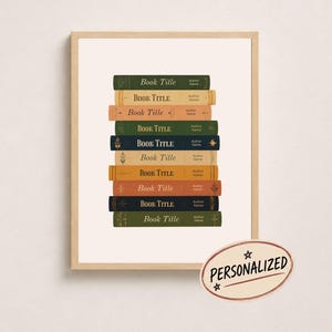 Könnte beinhalten: Ein gerahmter Druck mit einem Stapel aus neun Büchern in verschiedenen Farben wie Grün, Beige, Orange und Dunkelblau. Jeder Buchrücken zeigt den Text Book Title und Author Name. Ein ovales Abzeichen enthält den Text PERSONALIZED.
