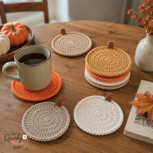 Könnte beinhalten: Ein Set aus runden, gehäkelten Untersetzern in verschiedenen neutralen und herbstlichen Farben wie Orange, Beige, Creme und Hellbraun. Jeder Untersetzer hat oben einen kleinen, braunen, strukturierten Stiel, der an einen Kürbis erinnert.