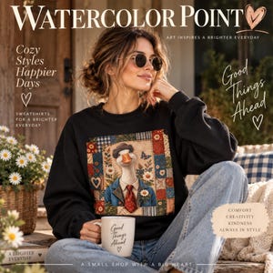 May include: A black long-sleeve sweatshirt featuring a central graphic of a goose wearing a hat, blue jacket, and red tie, surrounded by a patchwork quilt pattern of blue, red, and cream squares with floral and heart motifs.
