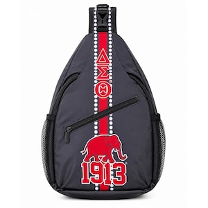 Op de afbeelding: Een zwarte sling-rugzak met een verticale rode streep met witgestippelde randen. Het ontwerp bevat de Griekse letters Delta Sigma Theta, een rode olifantafbeelding en het jaartal 1913 in het rood met witte omlijning. Het heeft zijvakken van gaas.
