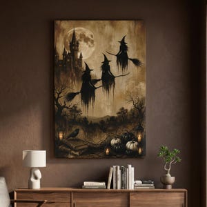 May include: A rectangular wall art print in sepia tones featuring three silhouettes of witches flying on broomsticks against a large full moon and a castle. The foreground displays a crow on stacked books, pumpkins, and lanterns with glowing lights.
