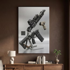 May include: A disassembled black rifle mounted on a silver metal stand, featuring a holographic sight, a textured grip, a magazine, and a separate tan-colored foregrip component, all displayed against a brushed metallic background.