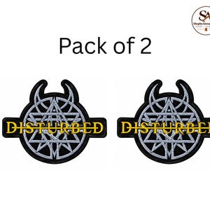 Op de afbeelding: Een set van twee geborduurde patches met een cirkelvormig ontwerp met een zilveren ster en hoornmotief op een zwarte achtergrond. Het woord DISTURBED is in gele hoofdletters in het midden van elke patch geborduurd met een zwarte rand.