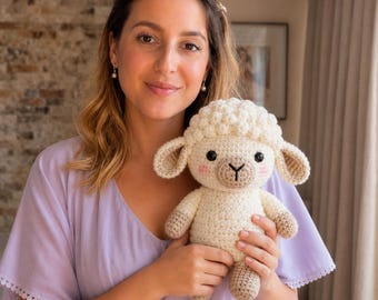 Può includere: Un peluche a forma di pecora realizzato all'uncinetto color crema, con testa in lana riccia testurizzata, orecchie pendenti e muso color marrone chiaro. Il giocattolo presenta occhi di sicurezza neri, naso e bocca ricamati e guance rosa.