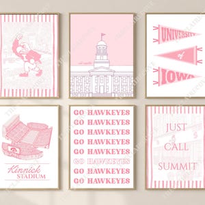 May include: A set of six pink and white wall art prints featuring University of Iowa themes. Designs include the Herky mascot, the Old Capitol building, three pennants, Kinnick Stadium, the text GO HAWKEYES repeated, and the text JUST CALL SUMMIT.
