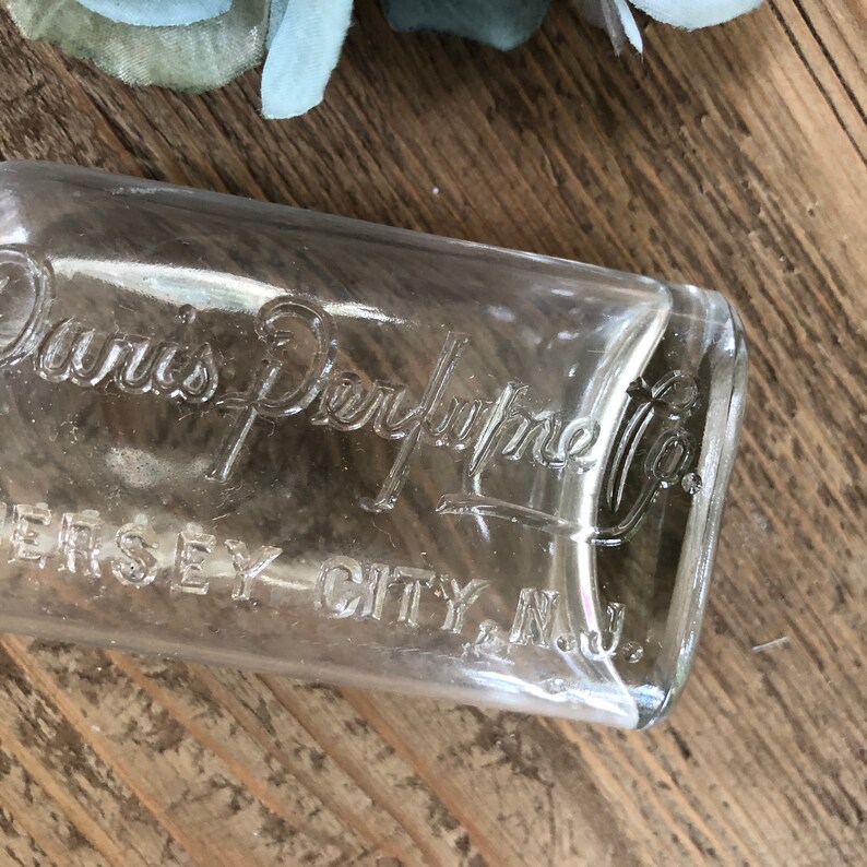 Puede incluir: Una botella de vidrio transparente con una etiqueta que dice "Davis Perfume Co. Jersey City, N.J."