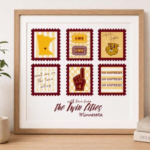 Pode incluir: Uma impressão artística quadrada emoldurada com seis ilustrações em estilo de selo postal em tons de bordô e dourado. Os designs incluem um mapa de Minnesota, bilhetes UMN, uma mascote gopher, o texto 'meet me in the twin cities' e um dedo de espuma.
