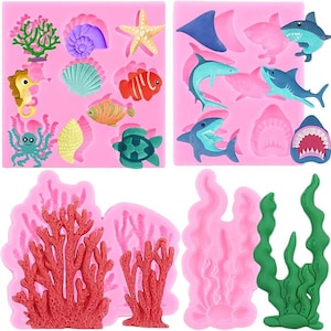 May include: A set of four pink silicone molds featuring various sea life shapes including coral, seashells, a starfish, a seahorse, an octopus, a turtle, tropical fish, and multiple sharks, alongside detailed red coral and green seaweed structures.