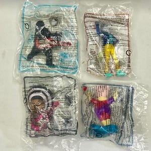 Könnte beinhalten: Vier kleine Kunststoff-Actionfiguren, einzeln in durchsichtigen Plastiktüten versiegelt. Die Figuren umfassen einen schwarzen Charakter, einen blau-gelben Charakter, einen mit schwarz-weiß gestreiftem Hut und einen lila-gelben Charakter.