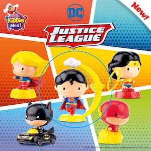 Op de afbeelding: Een verzameling van vijf Justice League-figuren, waaronder Superman, Batman, Wonder Woman, The Flash en Supergirl. Het Superman-figuur is gemarkeerd in een blauwe cirkel en heeft een gele halvemaanvormige basis en een wolk.