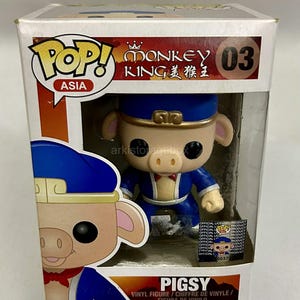 Peut inclure: Une figurine en vinyle Funko Pop Asia de la série Monkey King représentant Pigsy, numéro 03, dans sa boîte de présentation blanche d'origine. La figurine montre un personnage porcin portant un chapeau et une tenue bleus avec des bordures dorées.